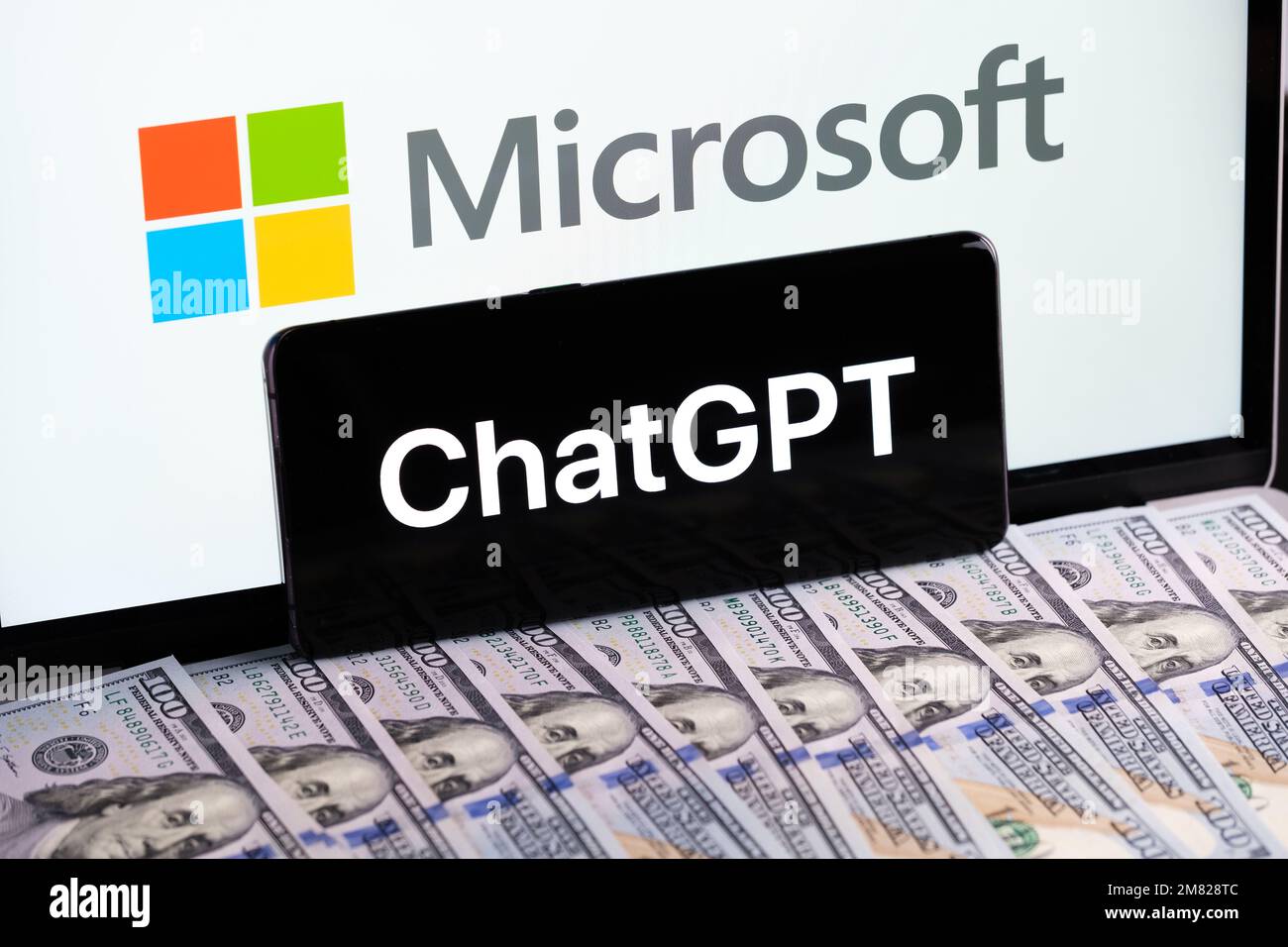 Logo ChatGPT vu sur le smartphone et LOGO MICROSOFT vu sur l'écran de l'ordinateur portable et des billets en dollars. Concept pour l'acquisition de la société OPENAI Chat GPT. Banque D'Images