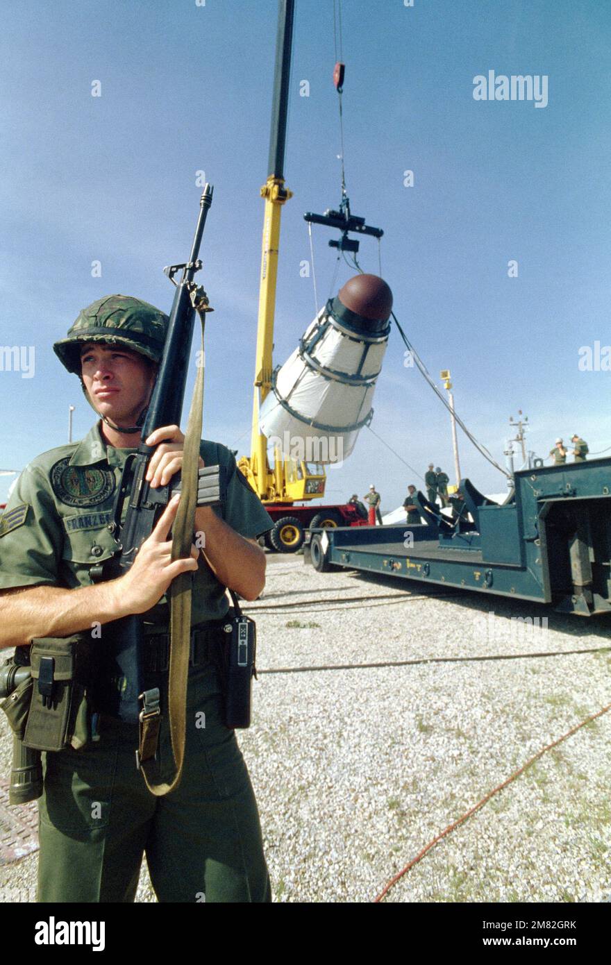 Un membre de l'escadron de la police de sécurité 381st, armé d'un fusil M16, se tient à l'état de garde lorsqu'un véhicule de retour Titan II est chargé sur une remorque. C'est le premier missile Titan II à être désactivé chez McConnell. Base : McConnell Air Force base État : Kansas (KS) pays : États-Unis d'Amérique (USA) Banque D'Images