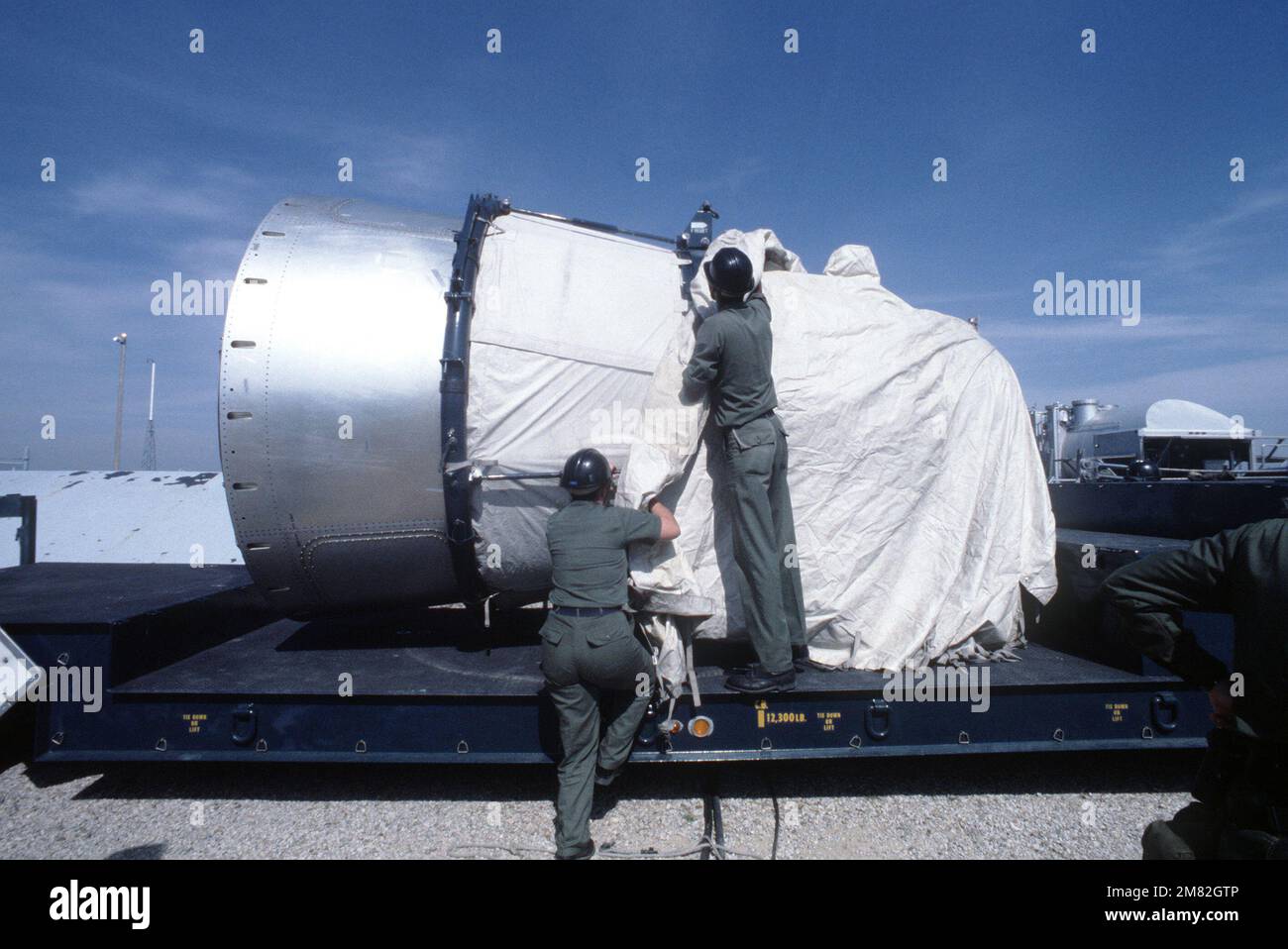 Les membres de l'aile stratégique des missiles 381st couvrent un véhicule de réentrée Titan II avant d'être transporté par une remorque jusqu'à la base. C'est le premier missile Titan II à être désactivé chez McConnell. Base : McConnell Air Force base État : Kansas (KS) pays : États-Unis d'Amérique (USA) Banque D'Images