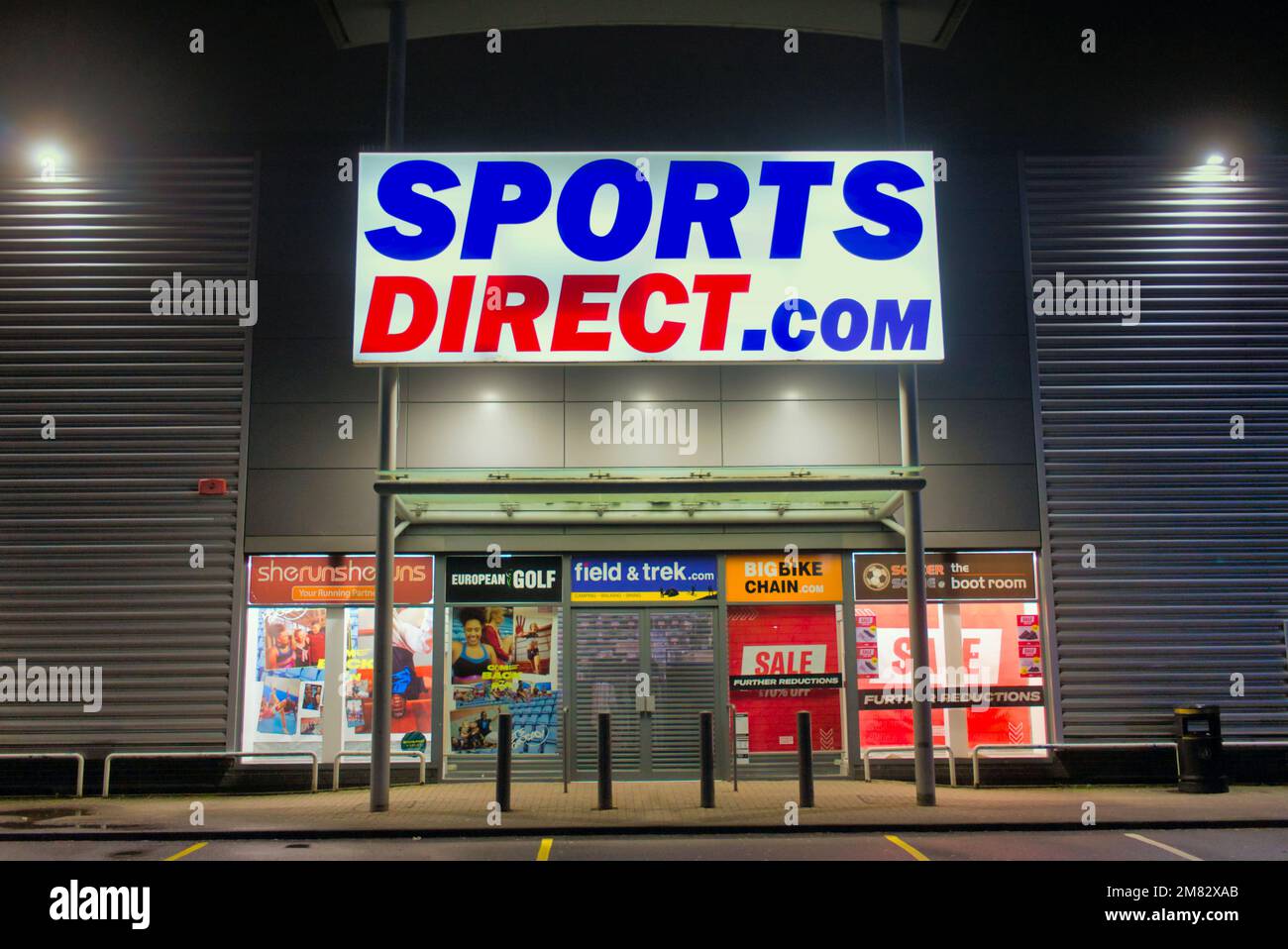 Panneau sport direct .com au-dessus de l'entrée principale la nuit sans personne Clyde Retail Park, Livingston Street, Clydebank Banque D'Images