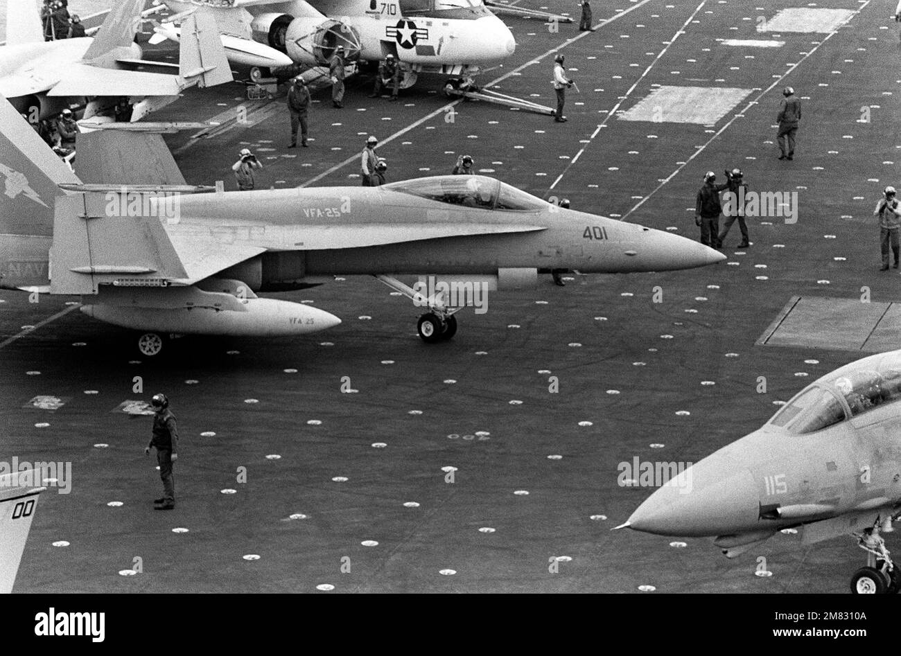 Un avion F/A-18A Hornet du Strike Fighter Squadron 25 taxis sur le pont de vol de la CONSTELLATION USS du porte-avions (CV 64) pendant l'exercice de flotte 85. Un avion Viking S-3A est entretenu en arrière-plan et un F-14A Tomcat est en train de rouler en premier plan. Base : USS Constellation (CV 64) pays : Océan Pacifique (POC) Banque D'Images