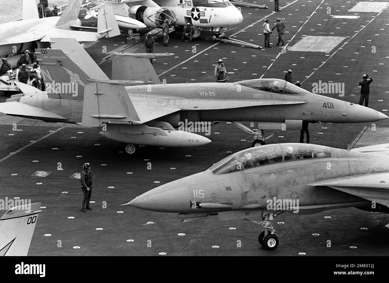 Un avion F/A-18A Hornet du Strike Fighter Squadron 25 taxis sur le pont de vol de la CONSTELLATION USS du porte-avions (CV 64) pendant l'exercice de flotte 85. Un avion Viking S-3A est entretenu en arrière-plan et un F-14A Tomcat est en train de rouler en premier plan. Base : USS Constellation (CV 64) pays : Océan Pacifique (POC) Banque D'Images