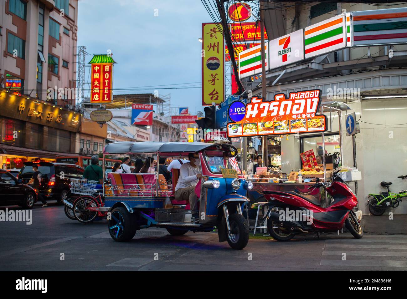 Bangkok, Thaïlande - 10 janvier 2023: Tuk-tuk devant le magasin 7-Eleven sur la route de Yaowarat à Bangkok, Thaïlande Banque D'Images