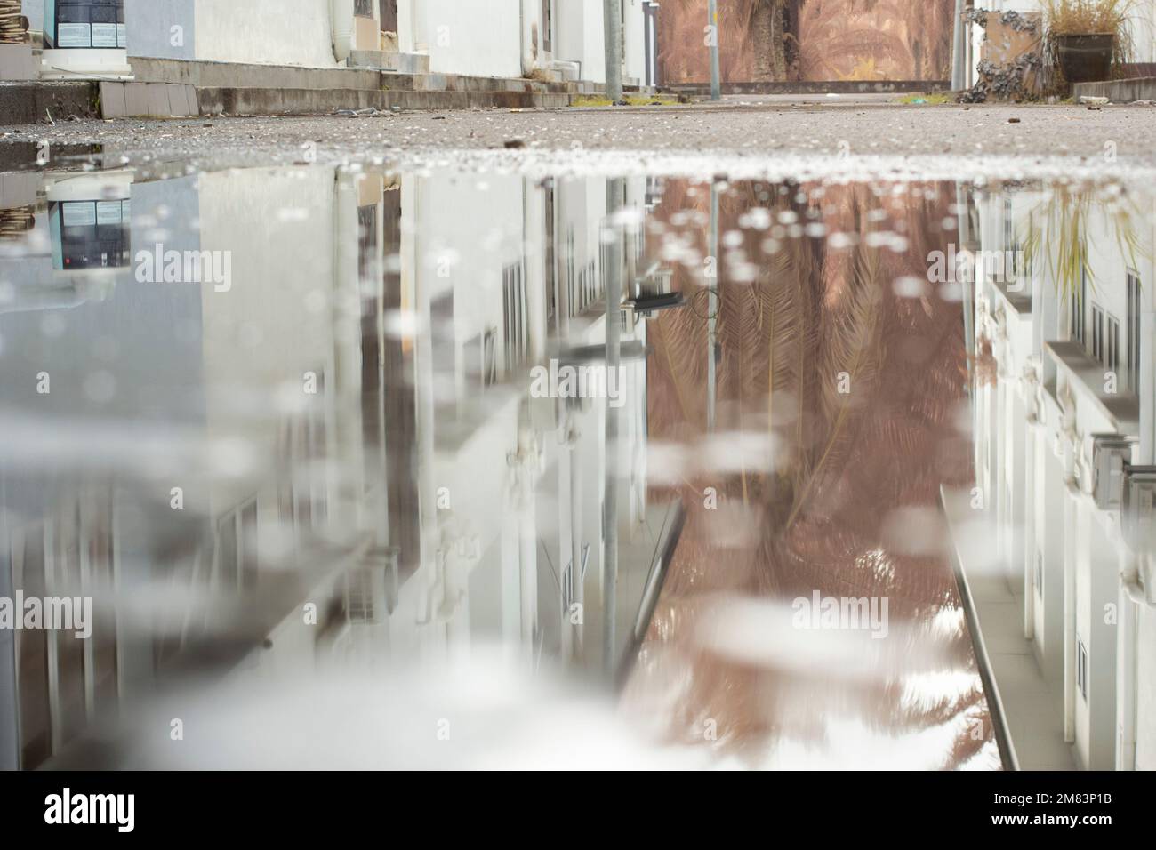 piscine d'eau stagnante après la pluie dans la rue asphaltée de la banlieue Banque D'Images
