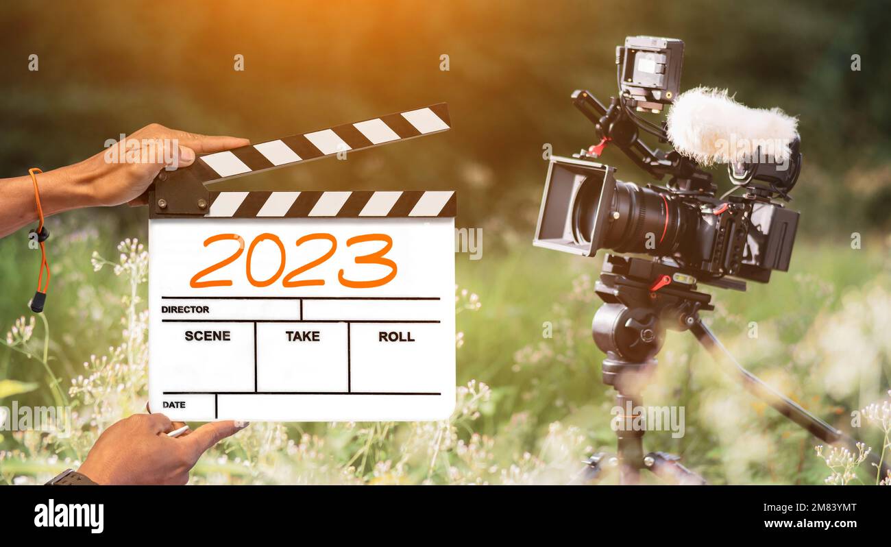 2023- manuscrit sur panneau de film. l'équipe de tournage tient un clapperboard et une caméra filmant un film en arrière-plan extérieur. pour le contenu du créateur Banque D'Images