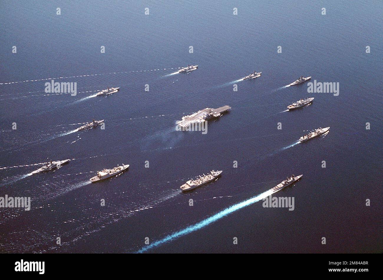 Vue aérienne du quartier à tribord du Battle Group Alfa en cours. LES NAVIRES SONT : (DANS LE SENS DES AIGUILLES D'UNE MONTRE, AU CENTRE DE L'AVANT) USS REEVES (CG-24), USS SAN JOSE (AFS-7), USNS MISPILLION (T-AO-105), OLDENDORF (DD-972), USS KANSAS CITY (AOR-3), USNS KILAUEA (T-AE-26), USS ENGLAND (USS USS 22), USS DFF-9, USS DFF-1087, USS WITH (DFF), USS KNOX (FF-1052), USS COCHRANE (DDG-21) ET USS MIDWAY (CV-41) (CENTRE). Base: Détroit de Makassar pays: Indonésie (IDN) Banque D'Images