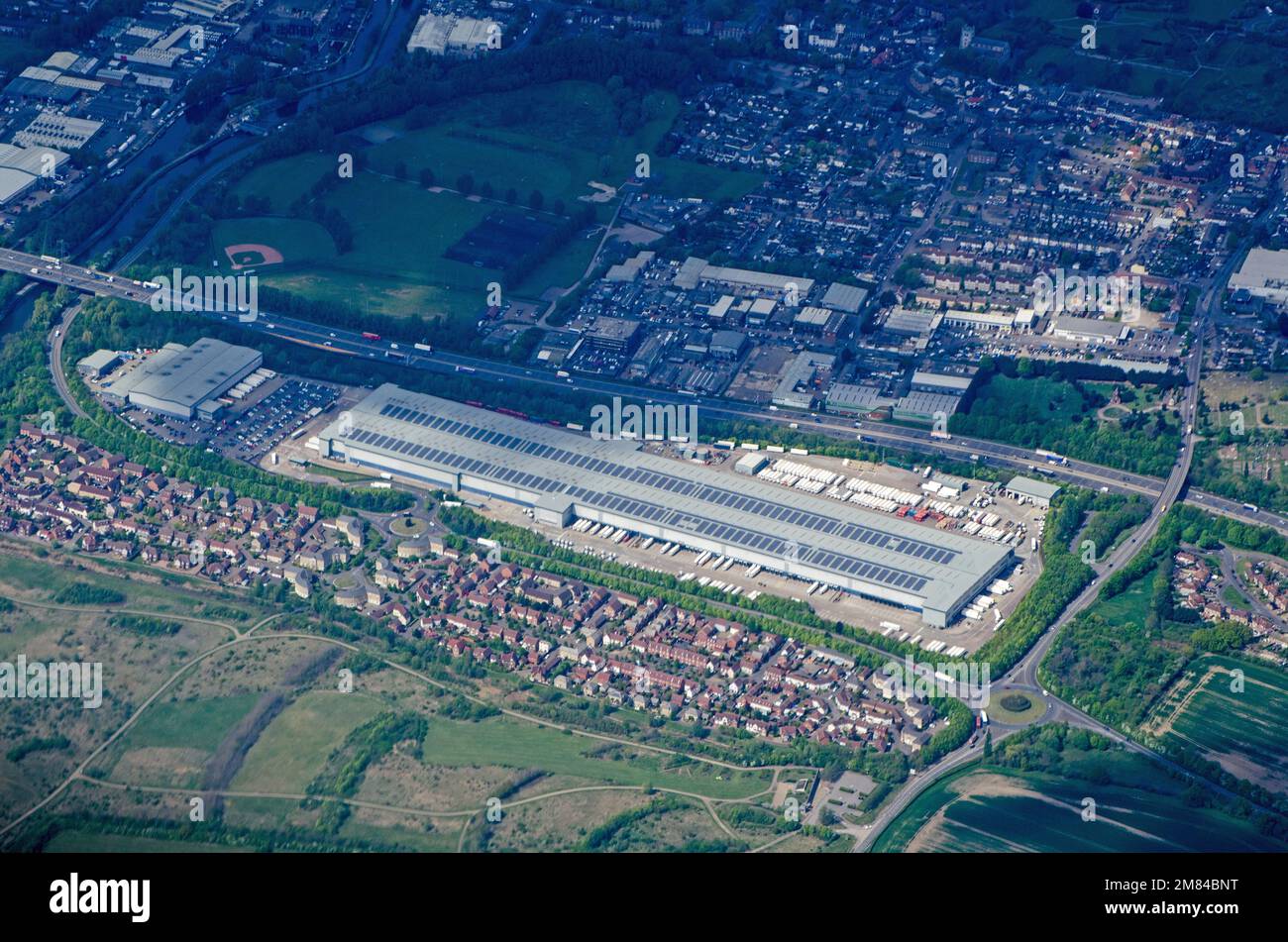 Vue aérienne de l'immense entrepôt exploité par le supermarché de Sainsbury le long de l'autoroute M25 à Waltham Abbey, Essex. Après-midi ensoleillé de printemps. Banque D'Images