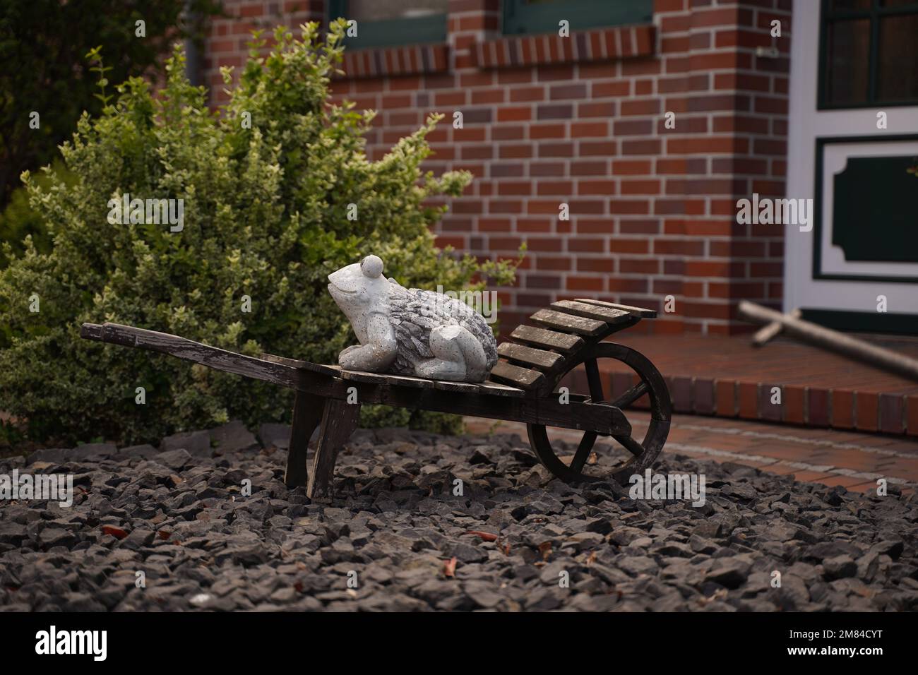 Brouette décorative avec grenouille en argile à l'intérieur Banque D'Images