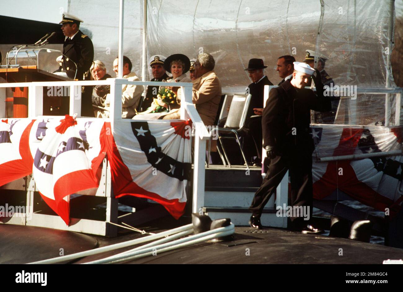 Le capitaine Raymond H. Setser, commandant éventuel du sous-marin d'attaque nucléaire USS PITTSBURGH (SSN 720), parle pendant la mise en service du navire. Carol H. Sawyer, commanditaire, est parmi les invités distingués sur la plate-forme. Base : base navale sous-marine, New London État : Connecticut (CT) pays : États-Unis d'Amérique (USA) Banque D'Images