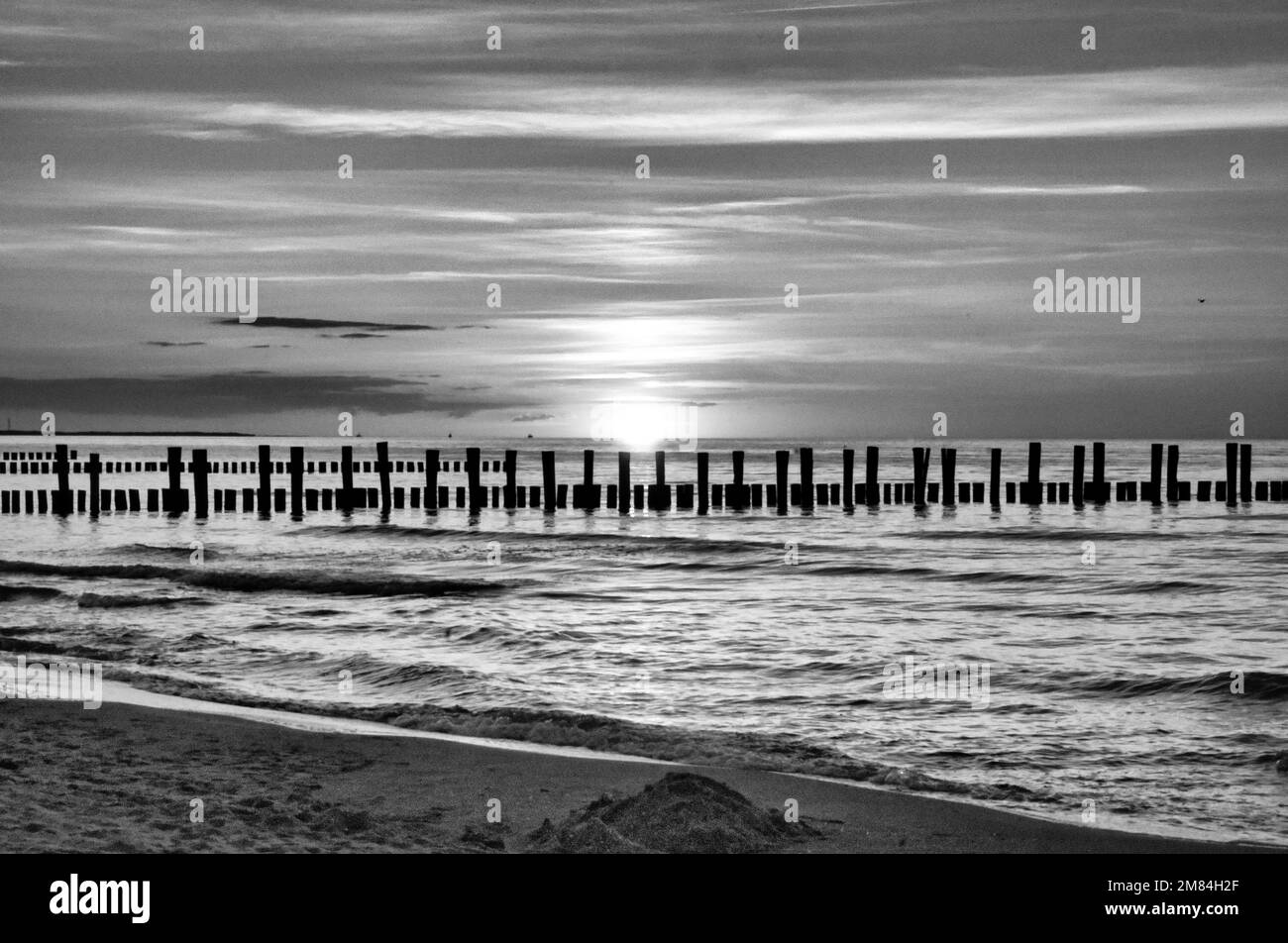 Coucher de soleil sur la mer Baltique en noir et blanc. Mer, groyne couleurs fortes. Vacances sur la plage. Ambiance romantique sur la côte. Photo paysage. Banque D'Images