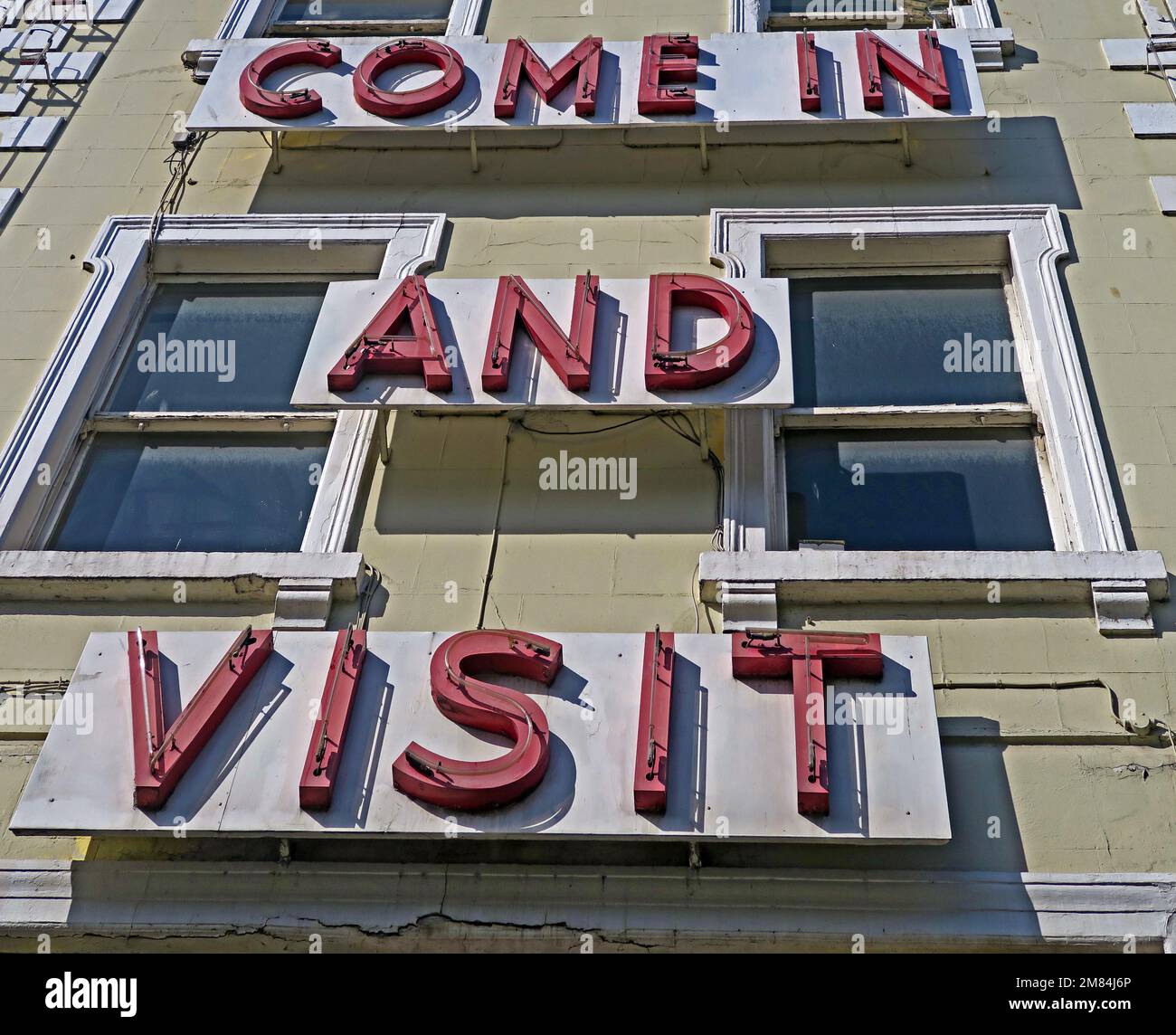 Entrez et visitez, enseigne au néon sur un bâtiment Banque D'Images