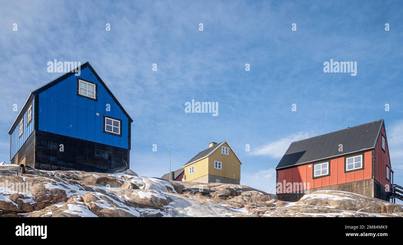 Maisons colorées accrochant sur le flanc de la montagne à Uummannaq dans l'ouest du Groenland Banque D'Images