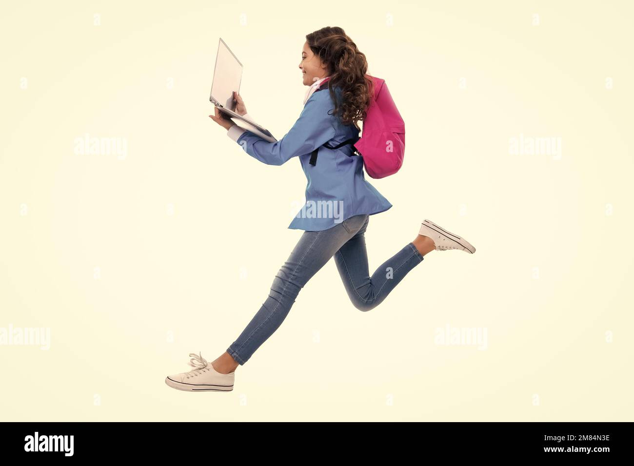 Enfant d'école, jeune fille étudiante avec ordinateur portable sur fond blanc isolé de studio. Courez et sautez, sautant un enfant. Concept de l'école et de l'éducation des enfants. Banque D'Images