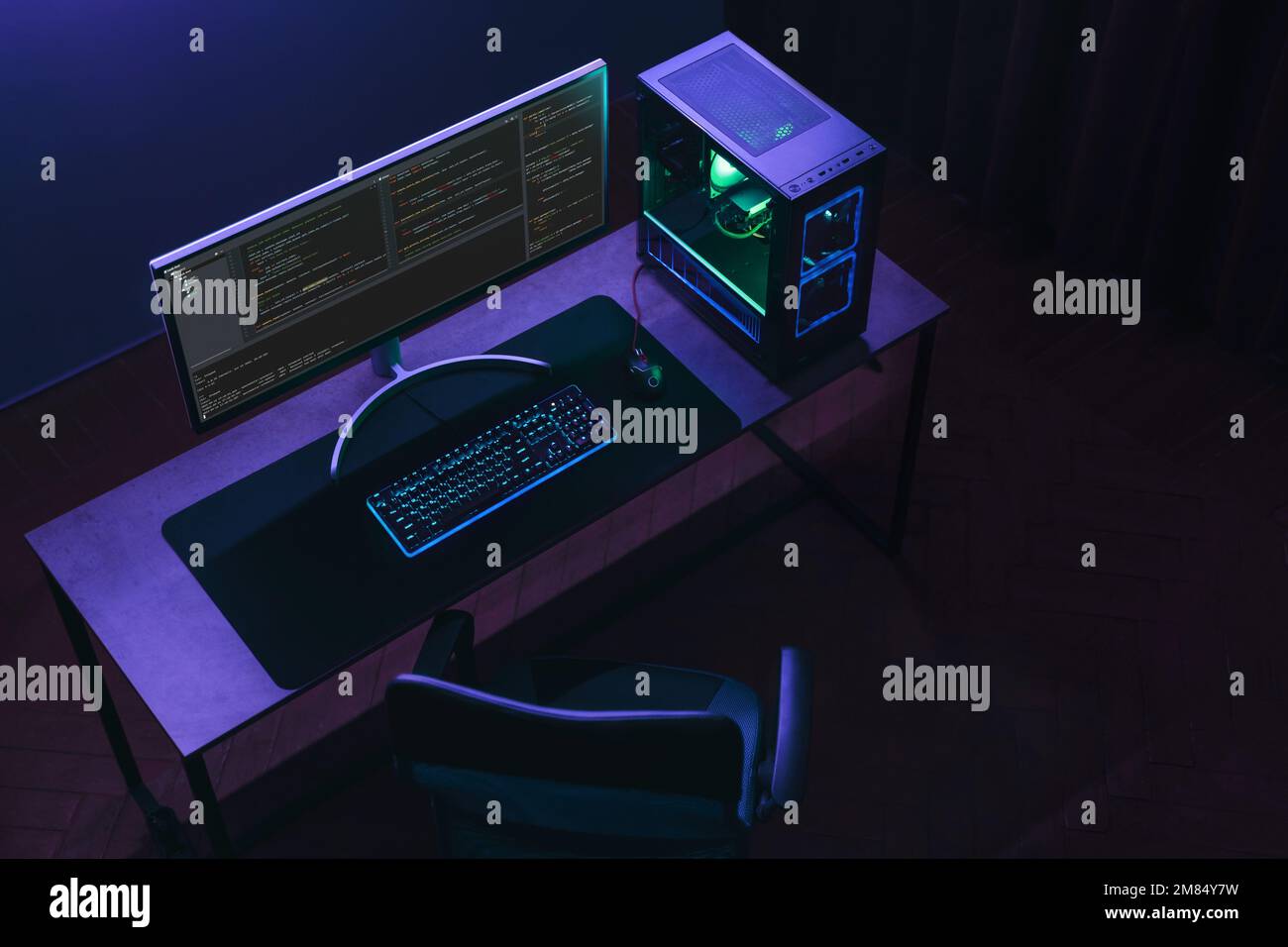 Vue de dessus de l'espace de travail du codeur à domicile avec configuration de programmation professionnelle. Vider le studio spécialisé EN INFORMATIQUE dans un éclairage au néon. Copier l'espace. Banque D'Images