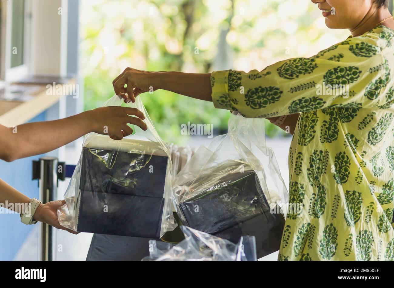 Serveuse donner la commande de plats à emporter à la cliente. Banque D'Images