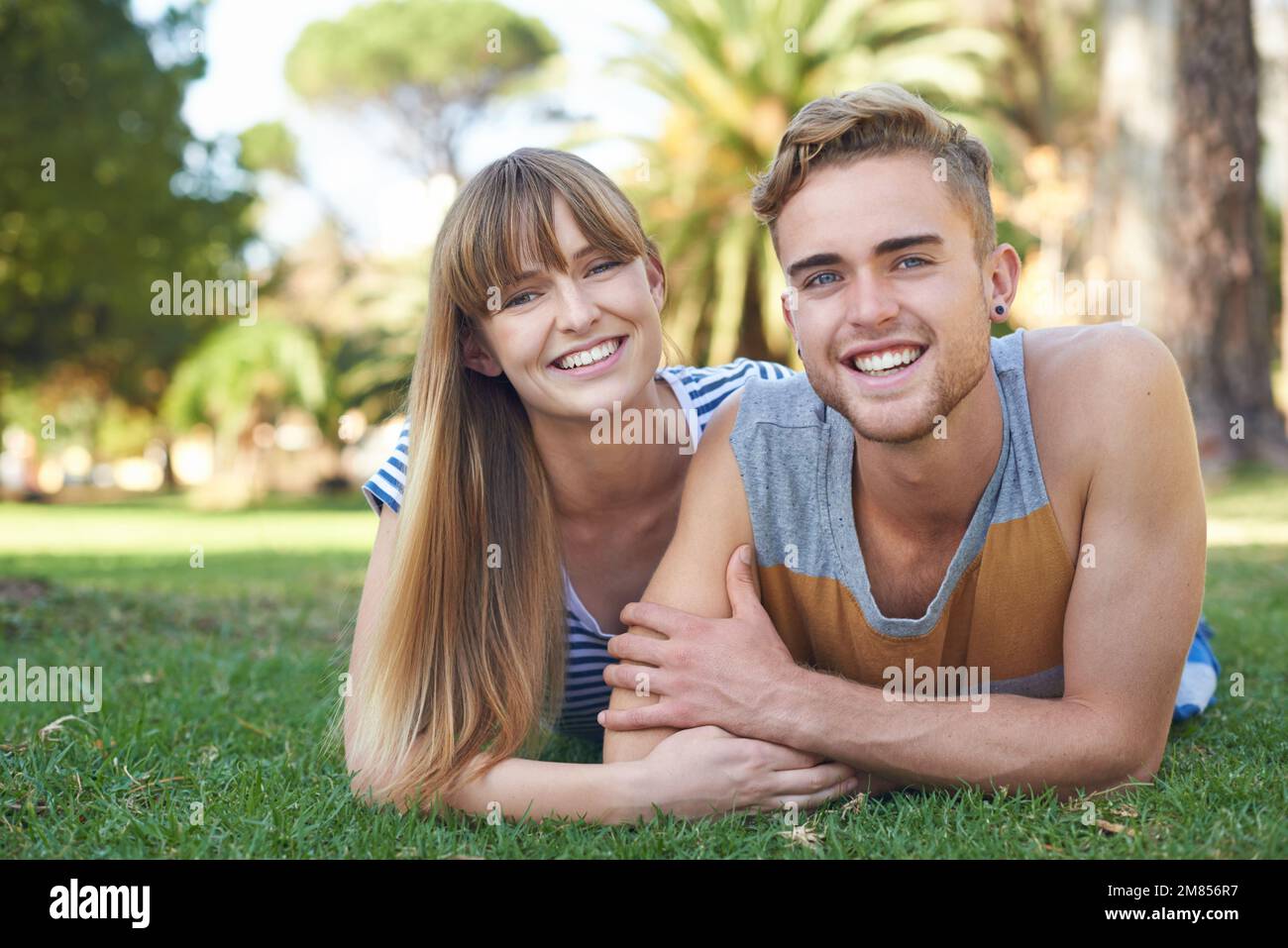 Détente dans le parc. Portrait d'un jeune couple heureux couché dans le parc. Banque D'Images