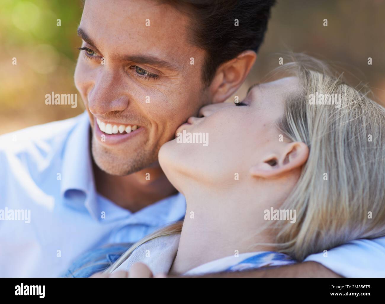 Elle se baise dans son adoration. Gros plan d'un jeune couple romantique montrant son affection à l'extérieur. Banque D'Images
