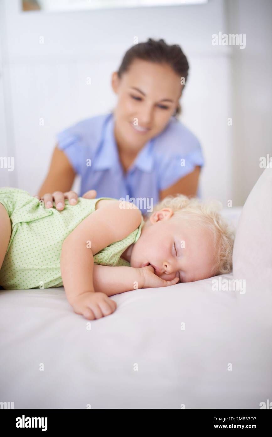 Amour maternel. une mère regardant son enfant endormi. Banque D'Images