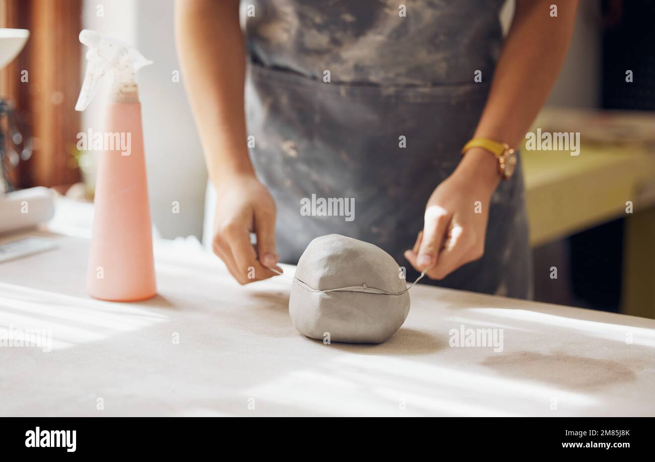 Femme, mains et argile coupée dans le studio de poterie, atelier et démarrage créatif pour le produit de sculpture. Artiste céramique, coupe-fil et procédé pour Banque D'Images