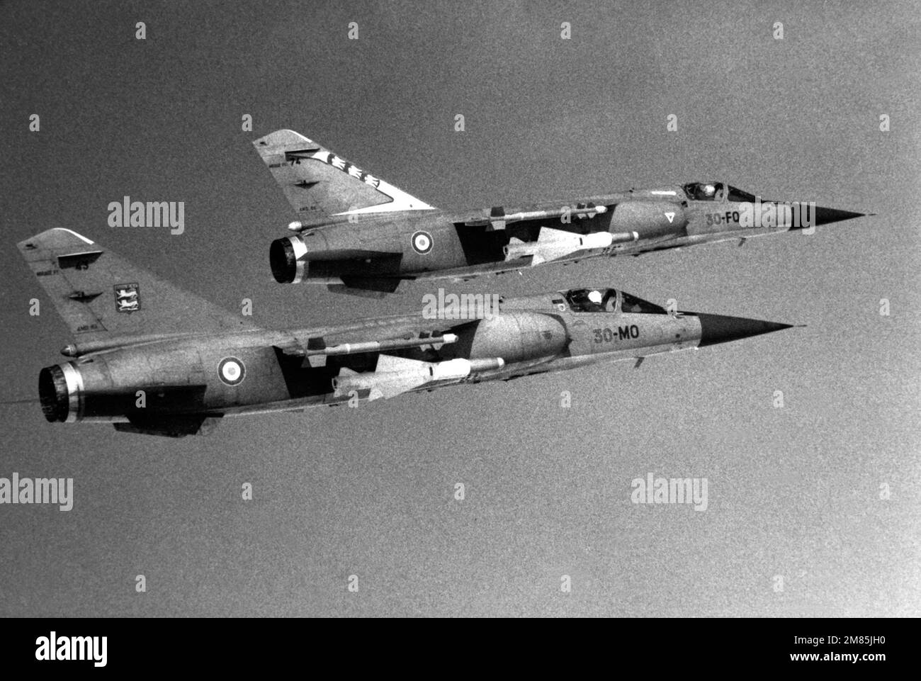 Vue aérienne à droite de deux avions de l'armée de l'air française Mirage F-1C armés de missiles air-air Matra 550 Magic montés sur les extrémités des ailes et de missiles air-air Matra R.530 montés sous le fuselage. Pays : inconnu Banque D'Images