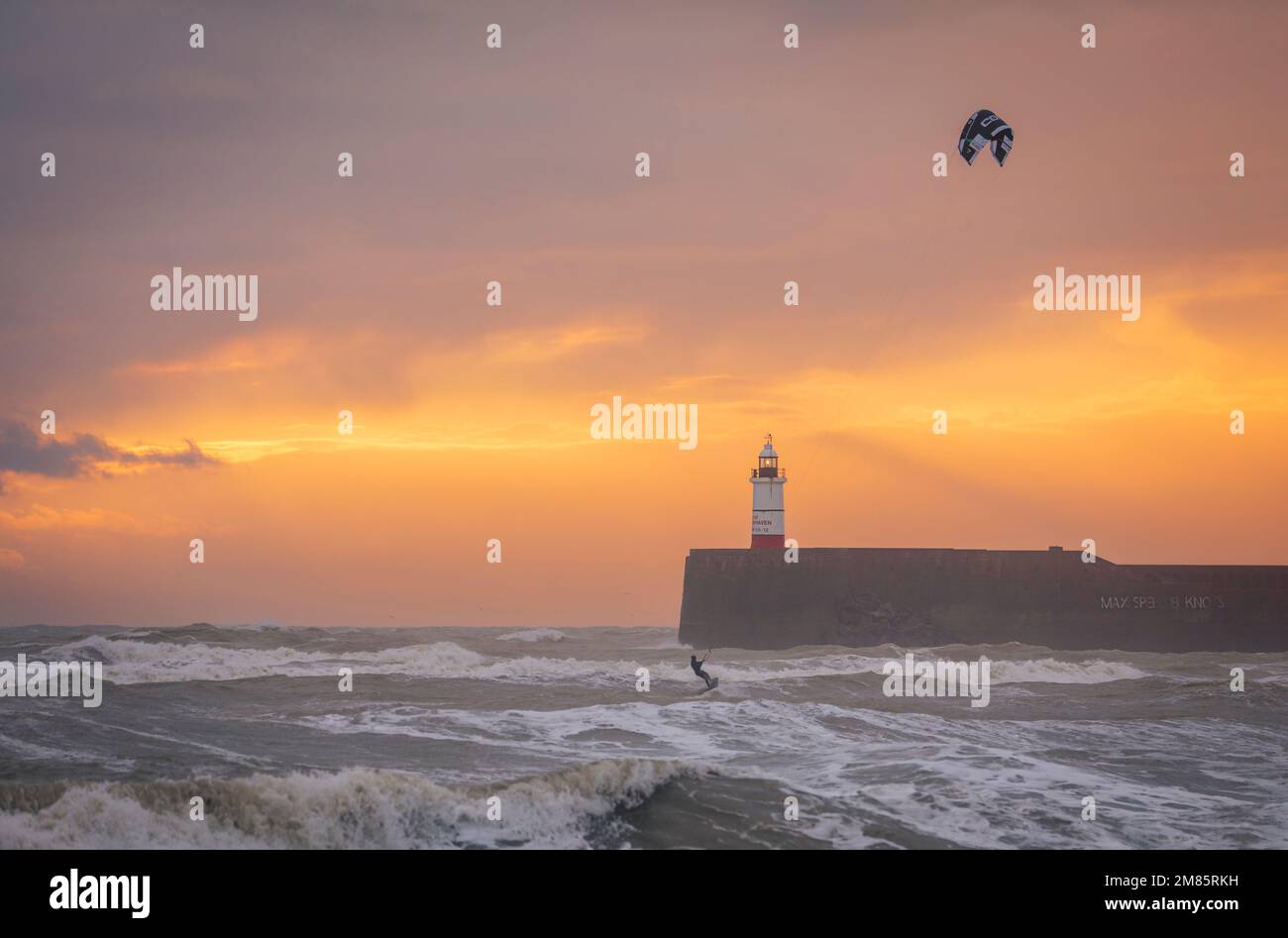 Cerf-volant sur une mer bâclée au coucher du soleil au phare de Newhaven et à la plage est Seaford est Sussex sud-est de l'Angleterre Banque D'Images
