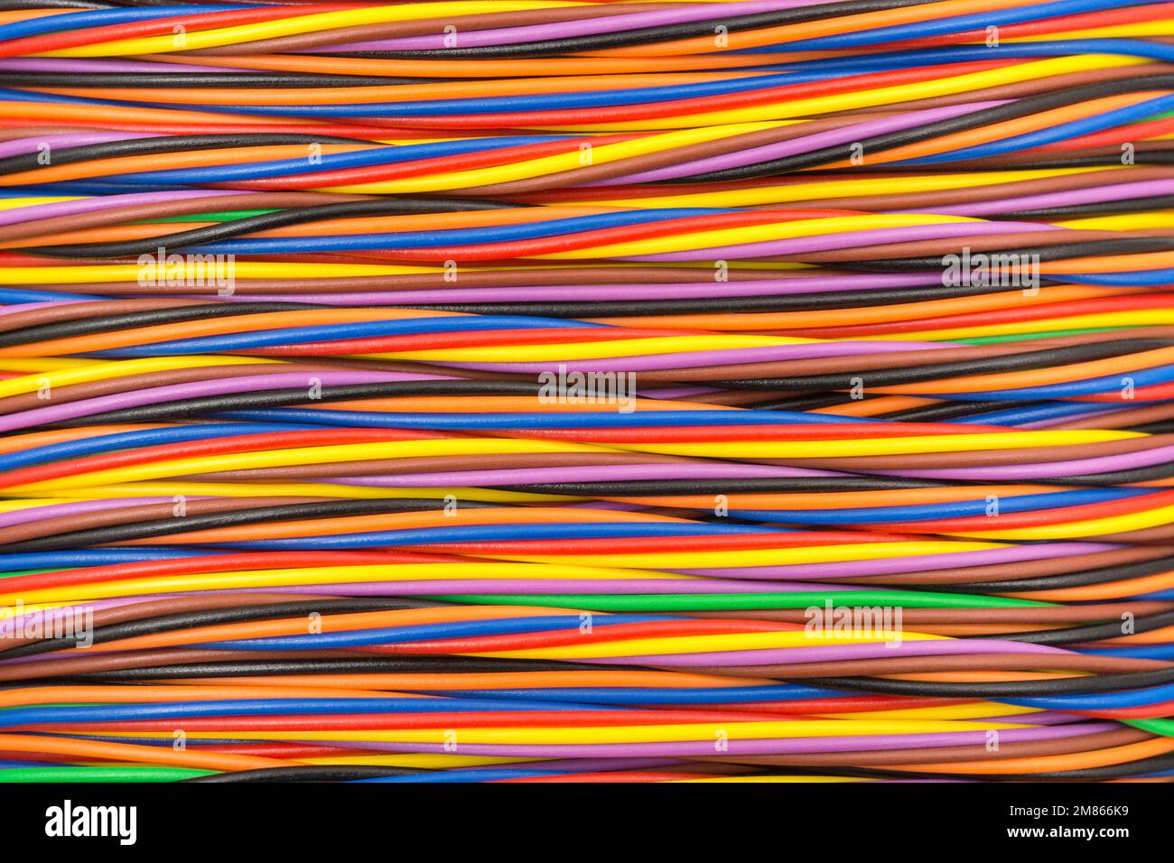 Gros plan d'une forme ronde multicolore enveloppée de fil électrique de calibre étroit (centre de mage raisonnablement aplati). Pour l'identification des couleurs des fils croisés Banque D'Images
