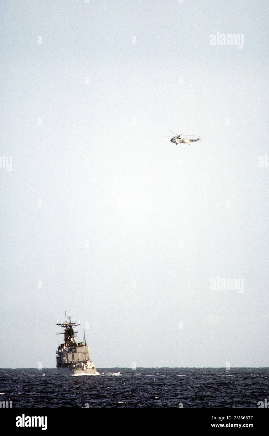 Vue du quartier portuaire du destroyer guidé USS KIDD (DDG-993) en cours pendant l'exercice de l'OTAN Northern Wedding '86. A ÉTATS-UNIS L'hélicoptère Sea King SH-3 de la Marine est au-dessus. Sujet opération/série: OTAN EXERCICE NORTHERN MARIAGE '86 pays: Inconnu Banque D'Images