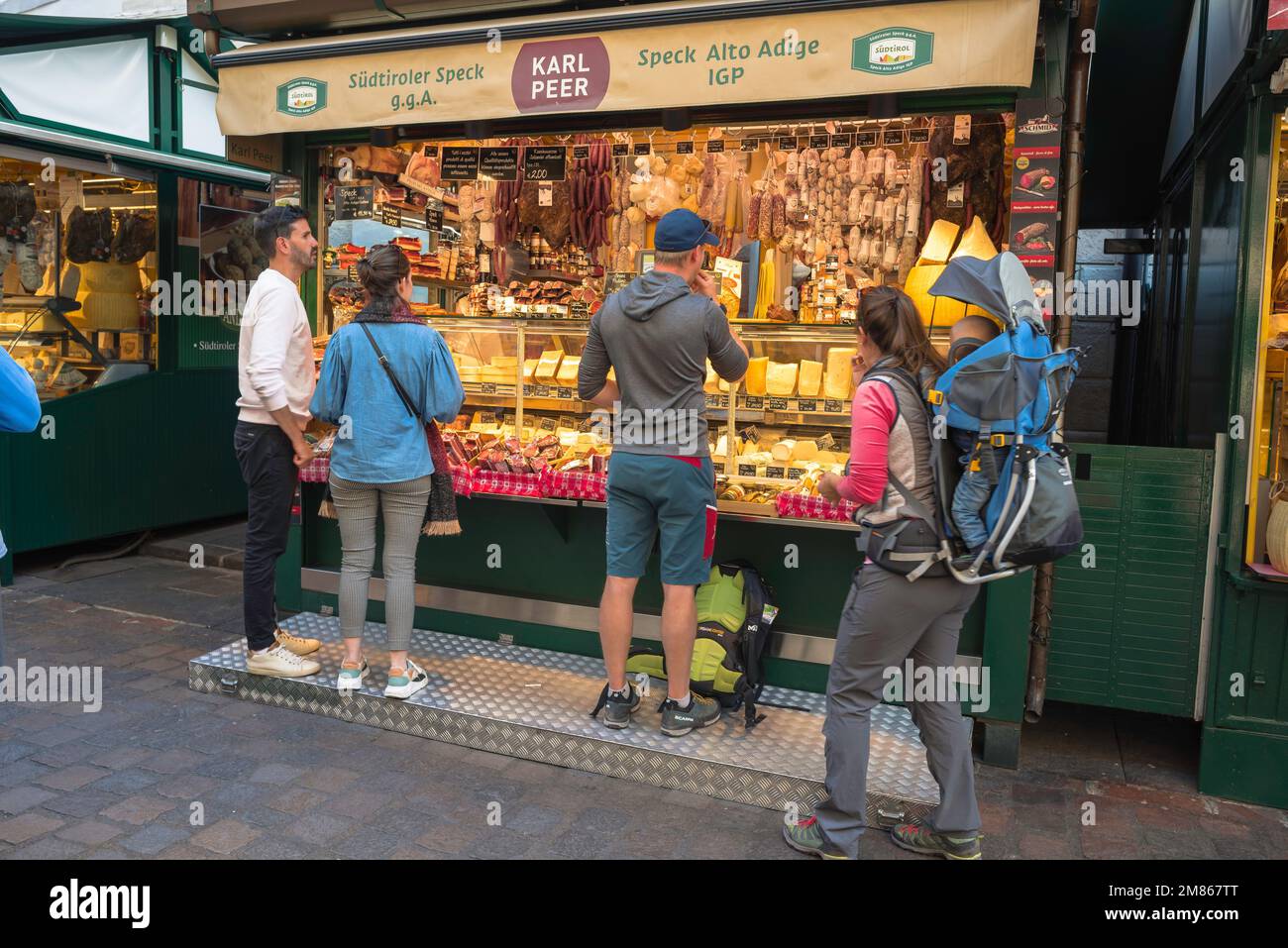 Marché de Bolzano, vue sur les personnes achetant de la nourriture dans un stand spécialisé dans les viandes et fromages locaux dans le marché Piazza Erbe, centre-ville de Bolzano, Italie Banque D'Images