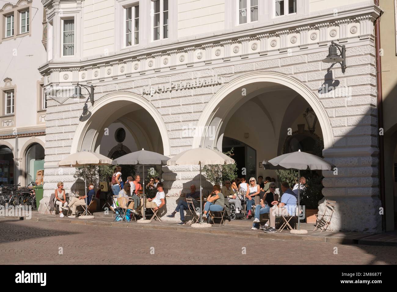 Bolzano café personnes, vue des personnes se détendant aux tables de café dans la via della Mostra (Mustergasse) dans le centre historique de la vieille ville de Bolzano, Italie Banque D'Images