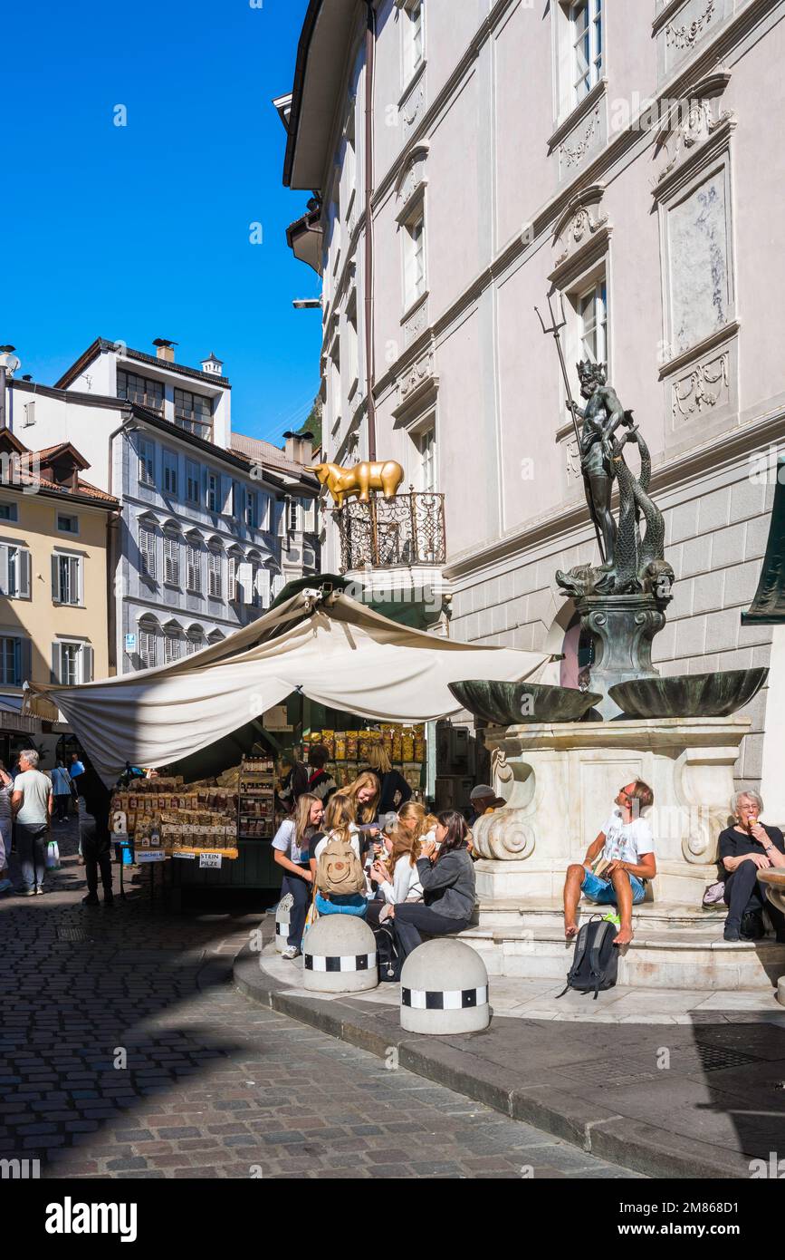 Fontaine de Neptune Bolzano, vue sur les personnes assises à côté de la Fontana Nettuno sur la Piazza Erbe, site du marché alimentaire historique de Bolzano en Italie Banque D'Images