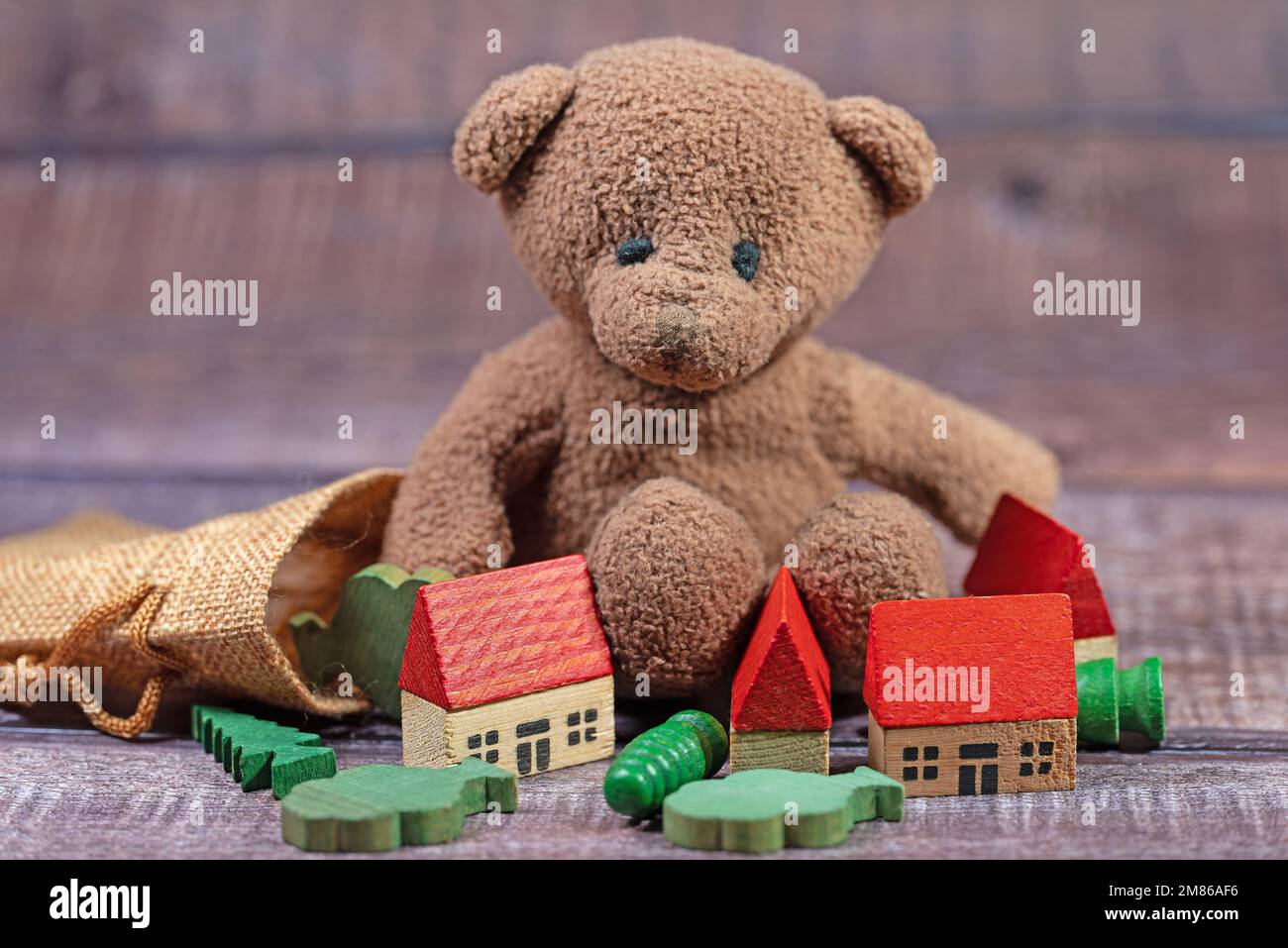 Ours en peluche et jouet en bois devant un fond blanc Banque D'Images