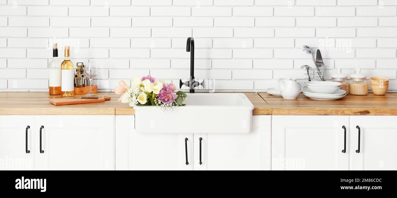 Lavabo propre avec beau bouquet de fleurs à l'intérieur de la cuisine  moderne Photo Stock - Alamy