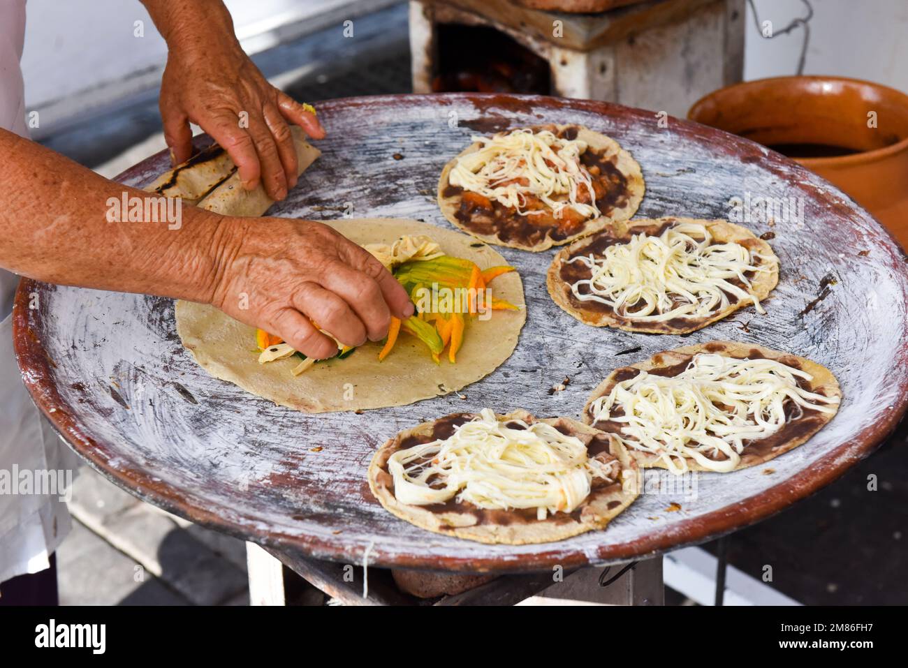 Tlayudas étant préparé dans une rue de nourriture dans la ville d'Oaxaca au Mexique Banque D'Images