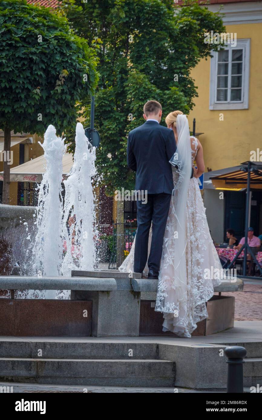 Nouveau wed couple mariée marié voile posant à une fontaine dans la vieille ville de Vilnius en Lituanie Banque D'Images