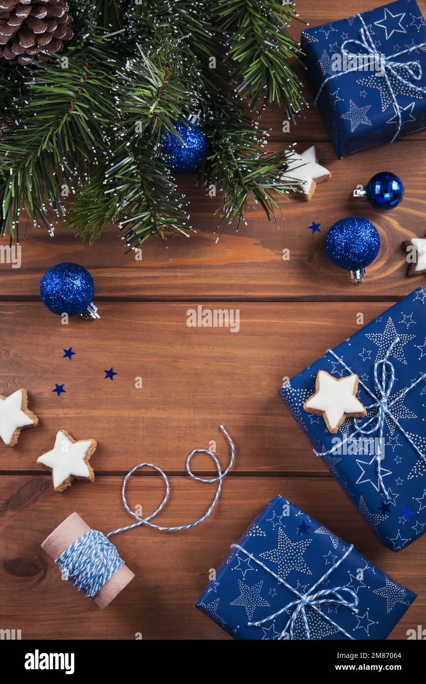 Composition de Noël. Cadeaux, branches de sapin, décorations bleues sur fond de bois. Concept de Noël, hiver, nouvel an. Plat, dessus Banque D'Images