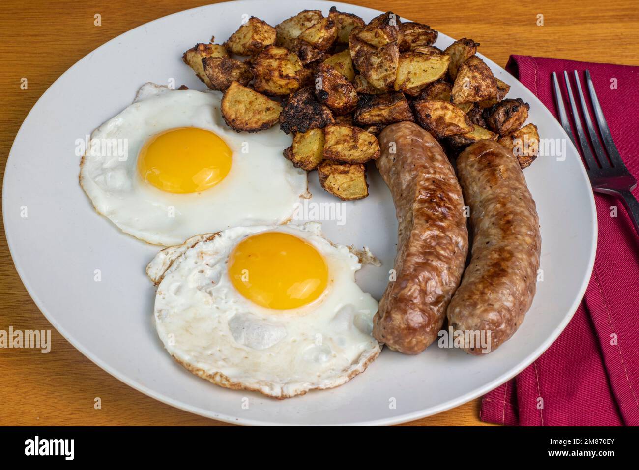 deux œufs servis avec des saucisses italiques et des frites maison Banque D'Images