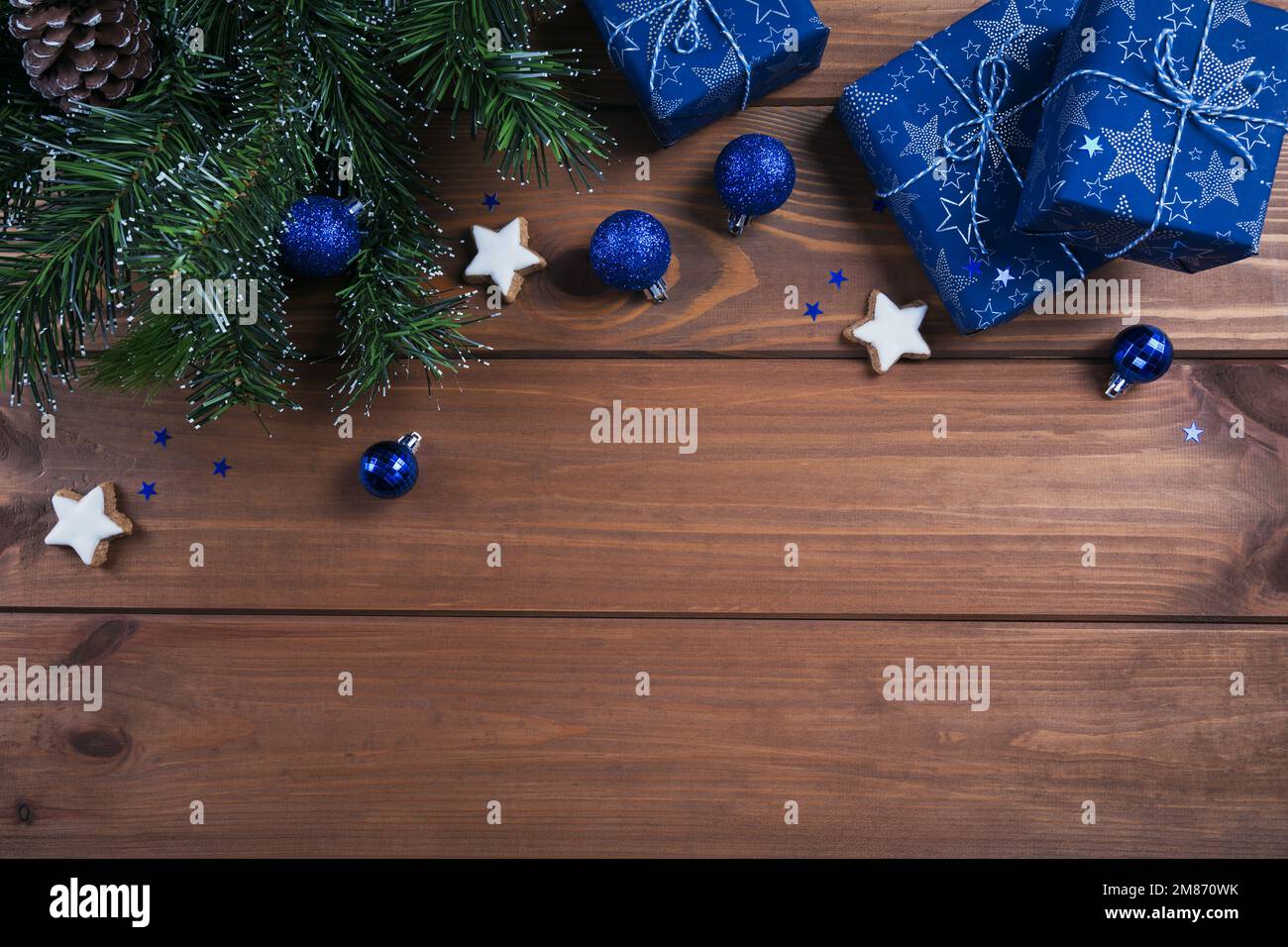 Composition de Noël. Cadeaux, branches de sapin, décorations bleues sur fond de bois. Concept de Noël, hiver, nouvel an. Plat, dessus Banque D'Images