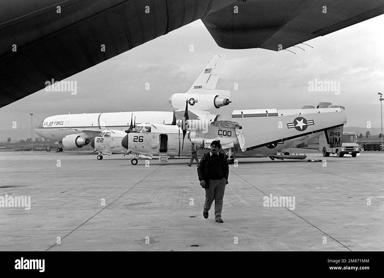Deux avions Greyhound C-2A du Fleet Logistics support Squadron 24 (VR-24), leurs ailes repliées, sont chargés à l'aérogare de la station. Derrière eux se trouve un avion de rallonge KC-10A de la US Air Force. Base: Naval Air Station, Sigonella État: Sicile pays: Italie (ITA) Banque D'Images