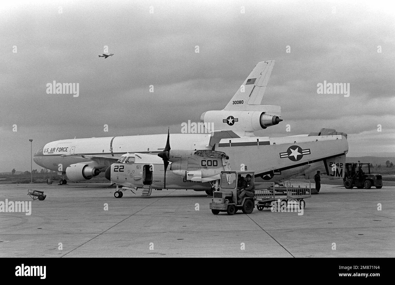 Un avion Greyhound C-2A du Fleet Logistics support Squadron 24 (VR-24), dont les ailes sont repliées, est chargé à l'aérogare de la station. Derrière eux se trouve un avion de rallonge KC-10A de la US Air Force. Base: Naval Air Station, Sigonella État: Sicile pays: Italie (ITA) Banque D'Images