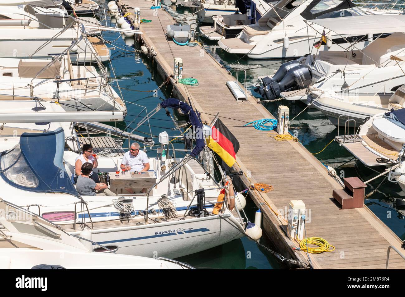 Au Club Nautico de Porto Cristo, Majorque trois amis profitent de la journée ensoleillée sur un voilier. Banque D'Images