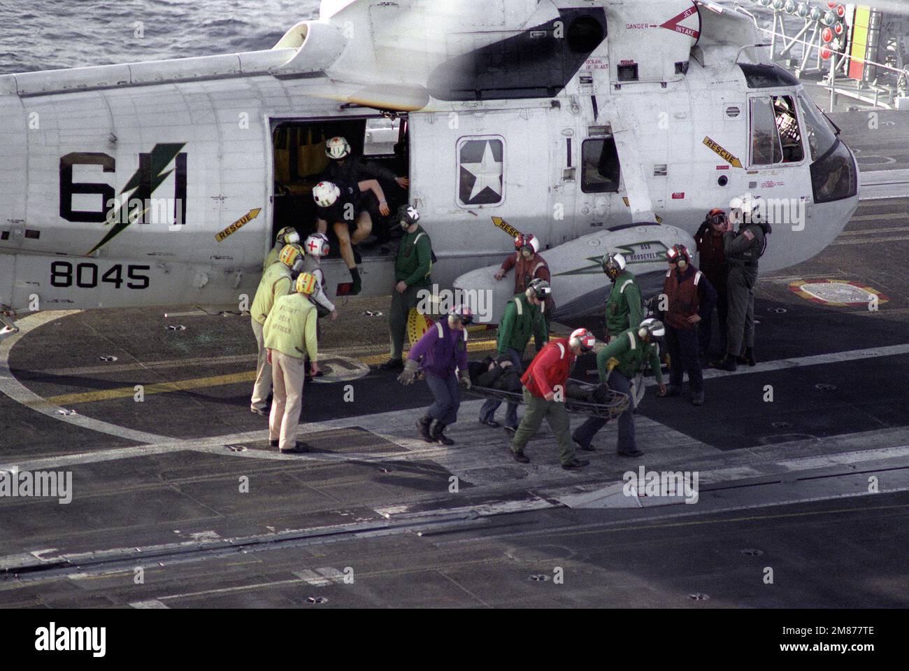 Une victime de l'accident est transportée d'un hélicoptère SH-3H Sea King de l'Escadron 11 (HS-11) d'hélicoptères anti-sous-marins sur le pont de vol du porte-avions à propulsion nucléaire USS THEODORE ROOSEVELT (CVN-71). Pays : inconnu Banque D'Images