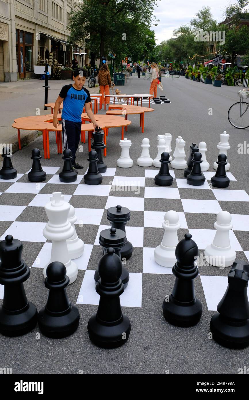 Les enfants jouent au jeu d'échecs dans la rue avec des pièces d'échecs de grande taille et un jeu d'échecs dans la rue du mile End dans le plateau Mont Royal.Montreal.Quebec.Canada Banque D'Images