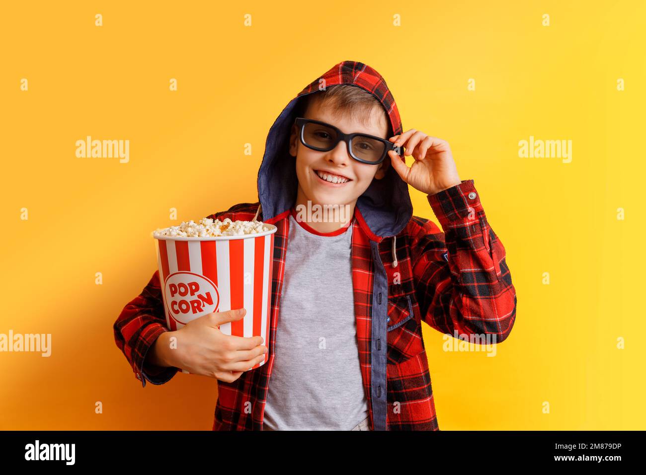 Joyeux garçon dans 3D verres avec seau à pop-corn Banque D'Images