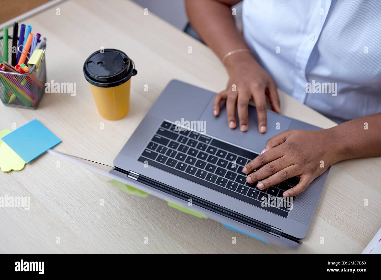 vue de dessus sur les mains noires de femmes dactylographiant sur le clavier d'ordinateur portable, travaillant en ligne sur le bureau. copier l'espace. courte femme méconnue en chemise blanche. les gens, busi Banque D'Images