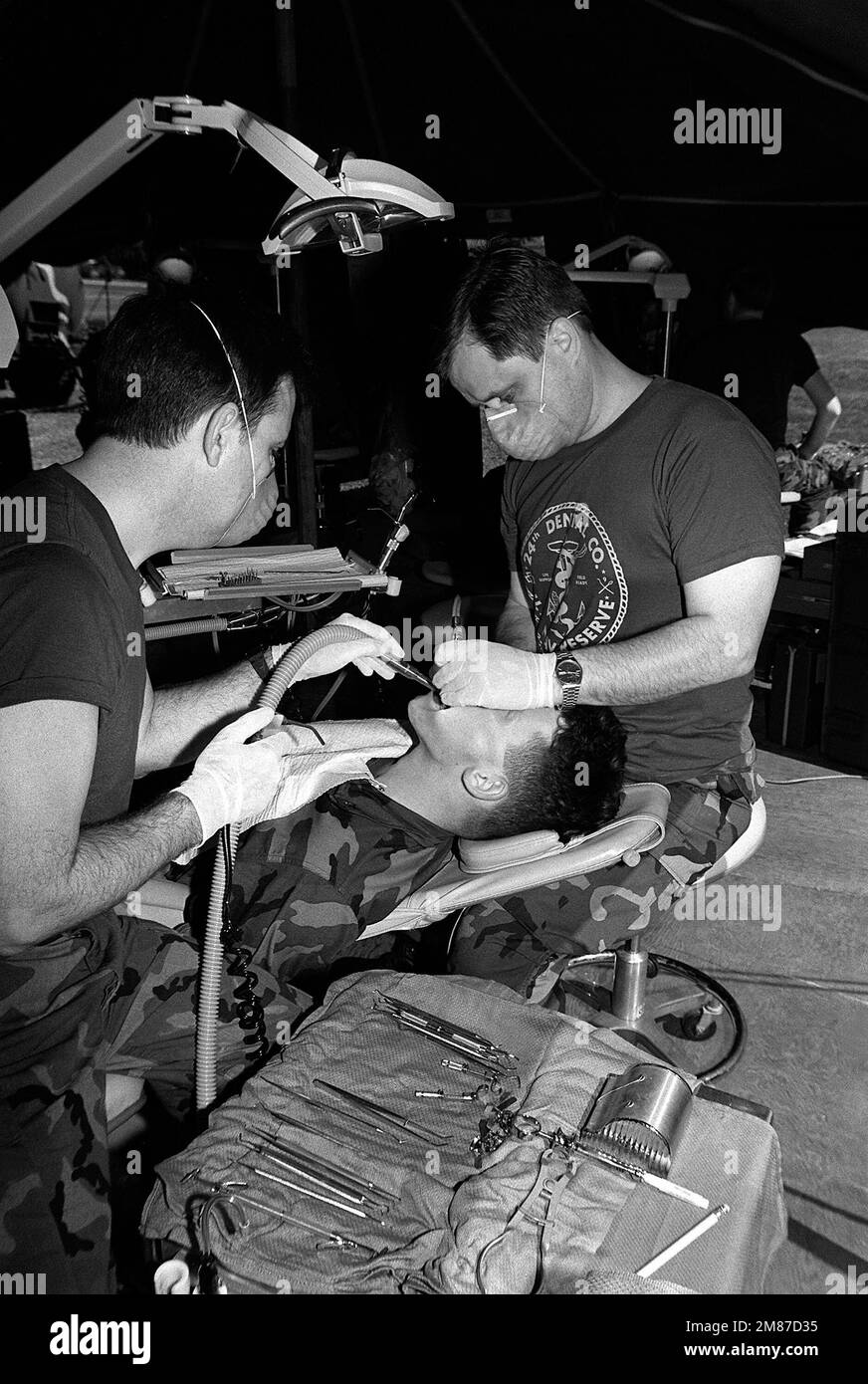 Dans une tente à l'extérieur de la clinique dentaire de la station aérienne, le technicien dentaire 1st classe James Christy, à gauche, assiste la DMCR. Richard Simmons comme il remplace un remplissage pour lance CPL. Calvin Turnage Jr. De Arbions Co., 3rd BN., 3rd Marines. Christy et Simmons, tous deux réservistes de la Marine affectés à la Compagnie dentaire 24th, sont à la station aérienne pour leur service annuel de formation. Base: Kaneohe Bay État: Hawaii (HI) pays: Etats-Unis d'Amérique (USA) Banque D'Images