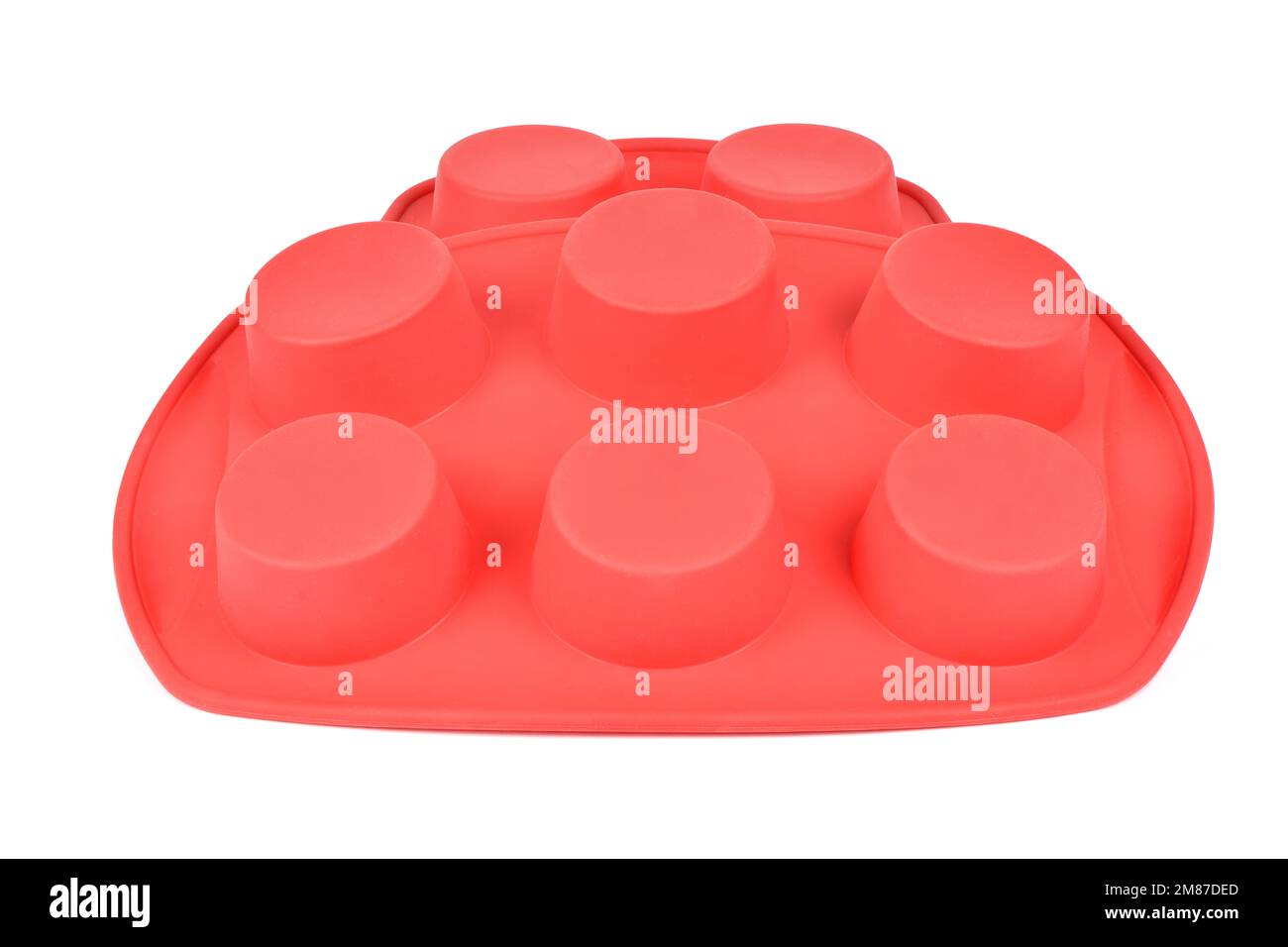 Forme en silicone rouge pour cuire des muffins et des cupcakes sur fond blanc. Vue latérale. Photo haute résolution. Profondeur de champ complète. Banque D'Images