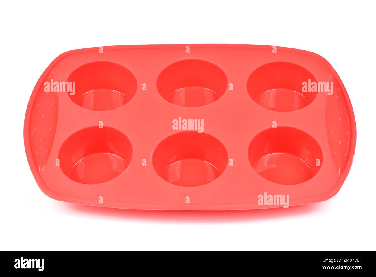 Forme en silicone rouge pour cuire des muffins et des cupcakes sur fond blanc. Vue latérale. Photo haute résolution. Profondeur de champ complète. Banque D'Images