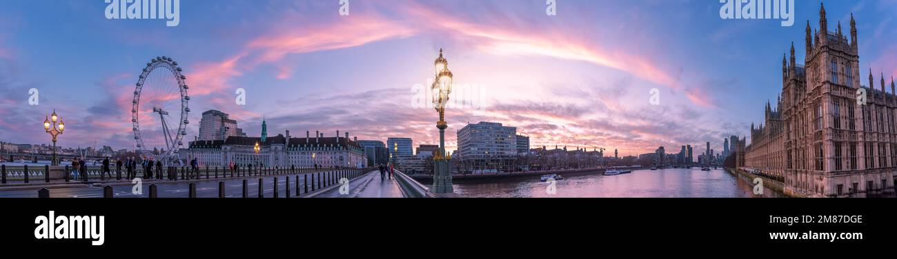 Londres, Angleterre, Royaume-Uni - 11 janvier 2023 : vue panoramique sur le pont de Westminster, le Parlement et le London Eye illuminés au lever du soleil Banque D'Images