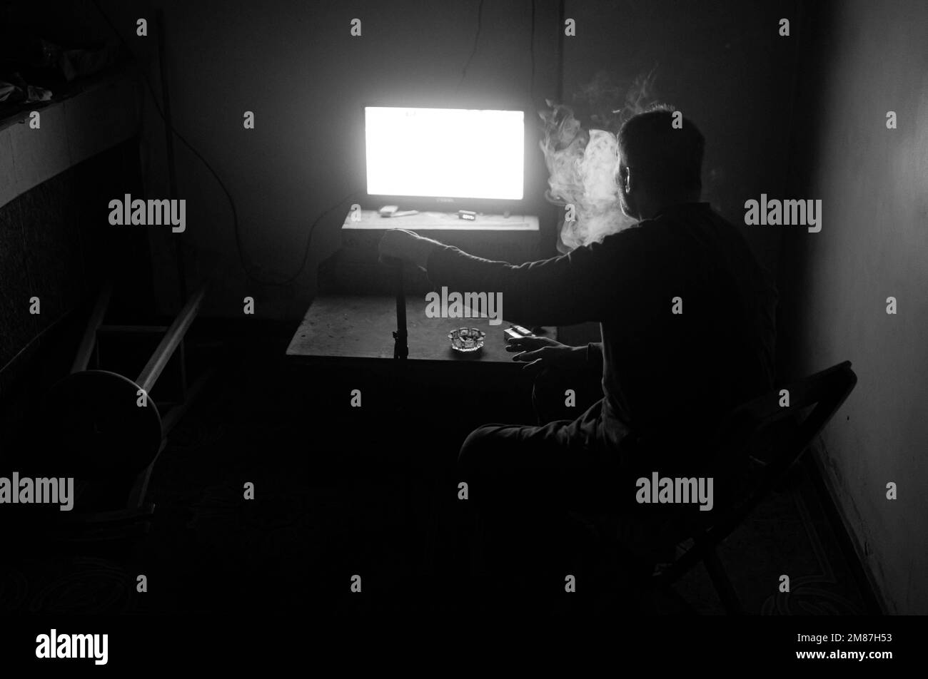 un vieil homme assis seul dans sa cuisine. Banque D'Images