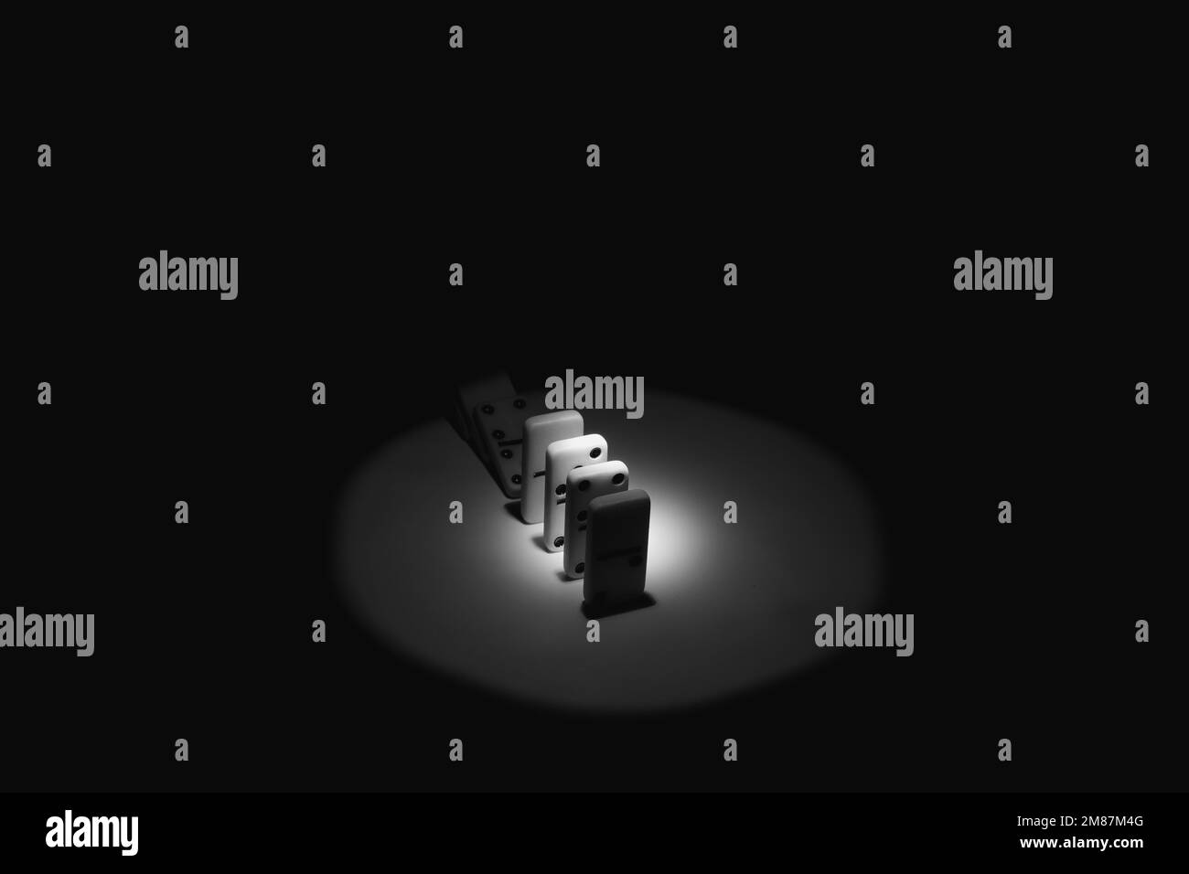 Dominos sur une table dans l'obscurité avec un faisceau de lumière, noir et blanc photo, jouer dominos gros plan photo Banque D'Images
